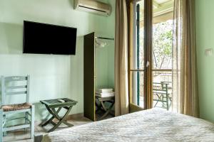 a bedroom with a bed and a television on a wall at Old Boat double studio 8 in Nikiana