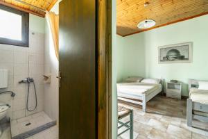 a bathroom with a shower and a bedroom with a bed at Old Boat double studio 8 in Nikiana