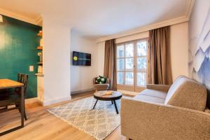 sala de estar con sofá y mesa en Résidence Les Arcs Le Village - maeva Home - Appartement pièces - Exclusiv 761, en Arc 1950