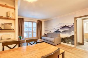 a living room with a couch and a table at Résidence Les Arcs Le Village - maeva Home - Appartement pièces - Exclusiv 761 in Arc 1950