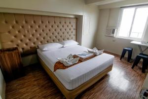 a bedroom with a large bed with a large headboard at DG Budget Hotel Salem in Manila