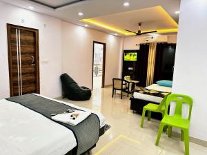 a bedroom with two beds and a table and chairs at Hotel Pink Paradise in Gorakhpur