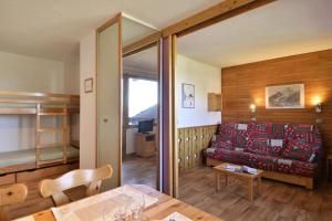 a living room with a couch and a table at Résidence Beryl - Studio pour 4 Personnes 10 in Mâcot La Plagne