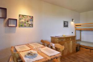 拉普拉尼馬孔的住宿－Résidence Beryl - Studio pour 4 Personnes 10，一间带桌子和双层床的用餐室