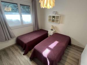 twee bedden in een kamer met een raam bij Appartement 2 chambres, climatisation, vue mer, refait à neuf en 2020 in Saint-Mandrier-sur-Mer