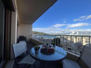 een balkon met een tafel en stoelen en uitzicht bij Appartement 2 chambres, climatisation, vue mer, refait à neuf en 2020 in Saint-Mandrier-sur-Mer