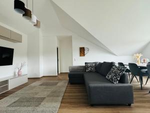 a living room with a couch and a table at Wunderschöne moderne Wohnung mit 2 Schlafzimmern in Braunfels