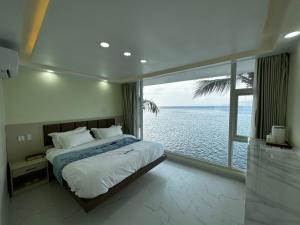 een slaapkamer met een bed en uitzicht op de oceaan bij Luckytito Anilao Resort in Mabini
