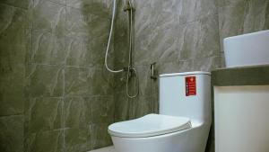 a bathroom with a toilet and a shower at Luna Prime Hub And Inn in Olongapo