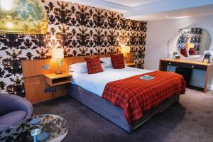 a hotel room with a bed and a chair at The Bull and Townhouse, Beaumaris- The Inn Collection Group in Beaumaris