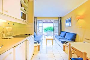 uma cozinha e sala de estar com um sofá e uma mesa em Résidence le Hameau de Cap Esterel - maeva Home - Appartement 2 Pièces 5 Pe 11 em Saint-Raphaël