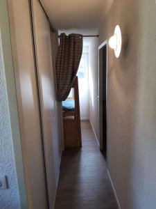 a hallway leading to a room with a table and a chair at Résidence Ecrin - Pièces 944 in Vénosc