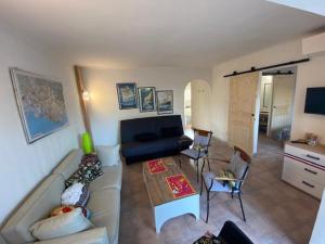 sala de estar con sofá y mesa en Bel appartement avec jardin à seulement 50 m de la plage et de Sanary.Climatisation, en Six-Fours-les-Plages