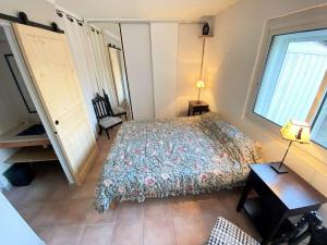 1 dormitorio con cama, escritorio y ventana en Bel appartement avec jardin à seulement 50 m de la plage et de Sanary.Climatisation, en Six-Fours-les-Plages