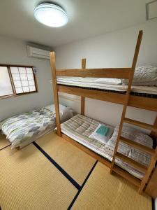 2 stapelbedden in een kamer met een ladder bij Kanazawa Guesthouse Stella in Kanazawa