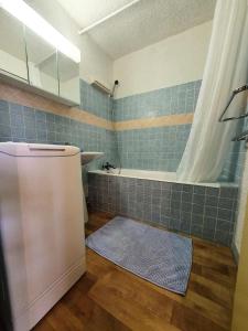 La salle de bains est pourvue d'une baignoire, d'une douche et d'un tapis. dans l'établissement Résidence Christiana - Studio pour 6 Personnes 554, à Risoul