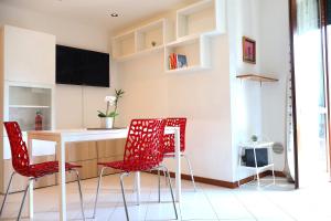 una cucina con sedie rosse, tavolo e bancone di [Monza] Monolocale completo a Monza
