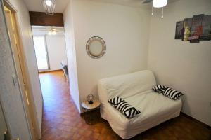 Habitación pequeña con cama blanca y almohadas de cebra. en Appartement 4 couchages à 100 M de la Plage en Saint-Elme