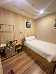 a small room with a bed and a night stand at Winny Hotel Ninh Kieu Quay in Can Tho