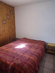 a bedroom with a bed with a red blanket at Chalets D Or - 2 Pièces pour 4 Personnes 164 in Vénosc