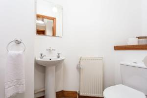 a white bathroom with a sink and a toilet at Cromwell Corner - Donnini Apartments in Ayr +12 photos