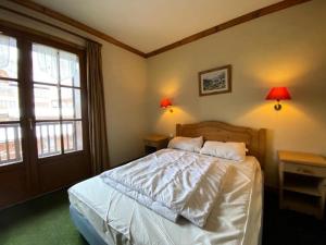 um quarto com uma cama com duas mesas e dois candeeiros em Résidence Alpina Lodge - 3 Pièces pour 6 Personnes 184 em Vénosc