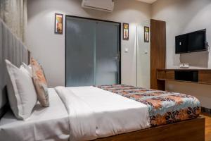 a hotel room with a bed and a tv at hotel galaxy in Surat