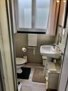 La petite salle de bains est pourvue d'un lavabo et de toilettes. dans l'établissement Sur la plage le bonheur, à Plestin-les-Grèves