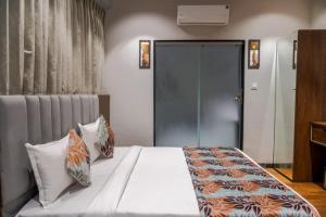 una camera con letto bianco e cuscini di hotel galaxy a Surat
