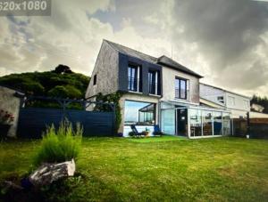 uma casa com um grande quintal com um relvado verde em Sur la plage le bonheur em Plestin-les-Grèves