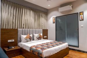 a bedroom with a large bed with a large window at hotel galaxy in Surat