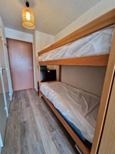 een slaapkamer met 2 stapelbedden en een houten vloer bij Résidence Le Diamant - Studio pour 4 Personnes 634 in Risoul