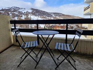 een tafel en 2 stoelen op een balkon met uitzicht bij Résidence Le Diamant - Studio pour 4 Personnes 634 in Risoul