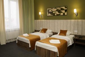 a hotel room with two beds with towels on them at BURSA in Taraz