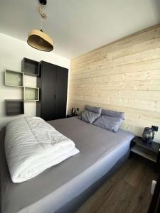 a bedroom with a large bed and a wooden wall at Résidence Olympe - 3 Pièces pour 8 Personnes 624 in Vénosc