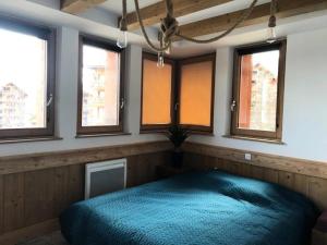 - une chambre avec un lit dans une pièce dotée de fenêtres dans l'établissement Résidence Antares - Pièces 064, à Risoul