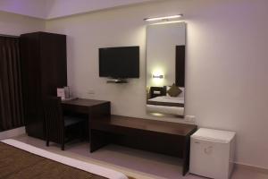 a hotel room with a desk and a mirror at HOTEL THE SENTOSA in Rajkot