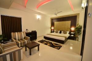 a hotel room with a bed and a chair at HOTEL THE SENTOSA in Rajkot