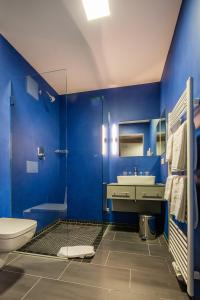 a blue bathroom with a toilet and a sink at Haus Overbach in Barmen