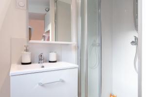 a white bathroom with a sink and a shower at Lille center equipped studio in Lille +6 photos