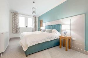 a bedroom with a large bed and a window at Firthview - Luxury 4 Bed 4 Bath - near Cow Shed in Anstruther