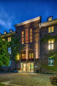 un edificio de ladrillo con luces rojas en las ventanas en Haus Overbach en Barmen