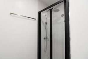 een douche met een glazen deur in de badkamer bij Cativo Design Apartment in Porto