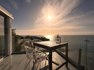 una mesa y sillas en un balcón con vistas al océano en El Ático Bonito, en Las Playitas