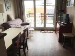 a living room with a couch and a table and a tv at Résidence Port Guillaume - maeva Home - 3 Pièces 6 Personnes Sélection MAE-1552 in Dives-sur-Mer