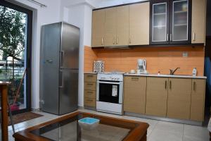 uma cozinha com um frigorífico de aço inoxidável e armários de madeira em Gina's Studio at Nafpaktos em Lepanto