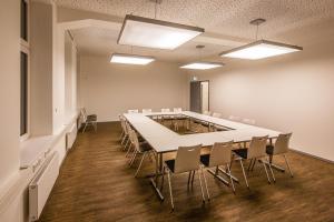 a conference room with a long table and chairs at Haus Overbach in Barmen