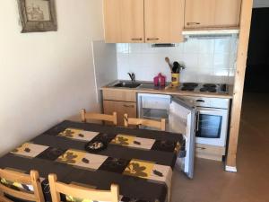 a small kitchen with a table and chairs and a stove at Résidence Estaris 1 - Studio pour 5 Personnes 604 in Orcières