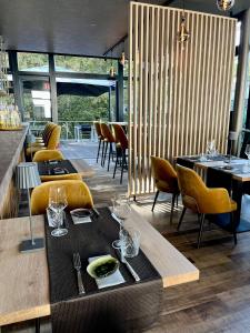 GiesenにあるParkhotel Ahrbergenのテーブルと椅子、ワイングラス付きのテーブルが備わるレストラン