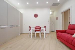 Una sala de estar con una mesa y un sofá rojo. en 4BNB - Ottaviano Vatican Flat, en Roma